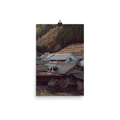 An idylic Japanese village tucked into the mountains of Asuka that looks straight out of the Edo Period. The image features colorful laundry hang drying on a line outside on a rooftop. 